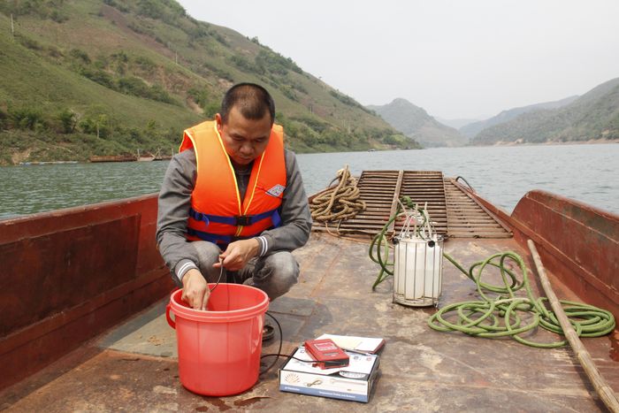 Quan trắc viên Trạm môi trường Tà Hộc, huyện Mai Sơn, lấy mẫu nước, đo các thông số tại hiện trường.