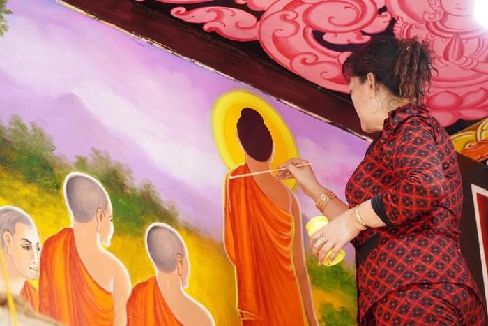 Nghệ nhân Sơn Sà The hoàn thiện bức vẽ.