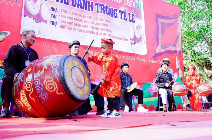 Trong hội thi đánh trống tế năm nay có nhiều em thiếu nhi tham gia, tuy nhỏ tuổi, nhưng chơi trống khá hay. Đặc biệt là em Nguyễn Cảnh Đạt (4 tuổi) trú ở xóm 6, xã Xuân Thành tham gia đội thi đánh trống tế với vai trò đánh trống cái cầm nhịp cho cả đội. Ảnh: An Nam
