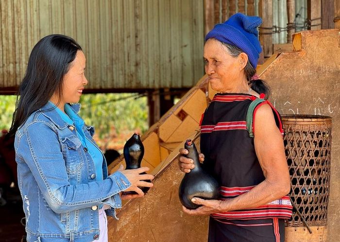 Chị Nguyễn Thị Hòa (bìa trái, thị trấn Kon Dơng, huyện Mang Yang) thích thú tìm hiểu về quả bầu khô của người Jrai. Ảnh: M.K