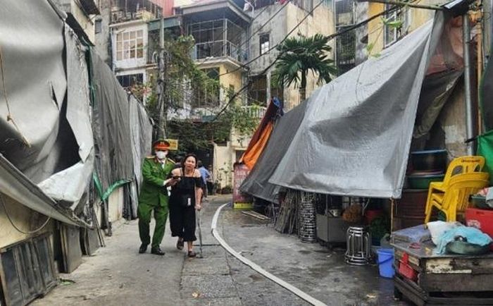 Lực lượng chức năng hướng dẫn, giúp đỡ người dân đến khu vực an toàn.