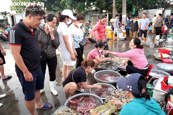  Du khách chọn mua hải sản tươi sống tại chợ bến cá. Ảnh: T.P 