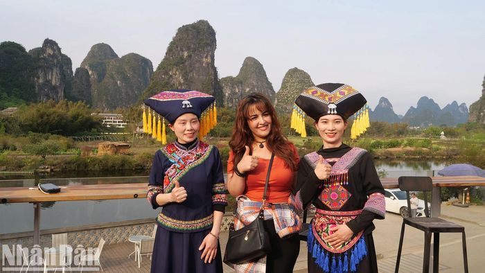 Du khách tìm hiểu phong tục, văn hóa địa phương và chụp ảnh lưu niệm với các cô gái dân tộc trong trang phục truyền thống.