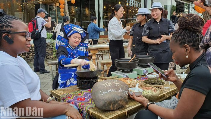  Du khách nước ngoài thưởng thức trà gạo rang - món ăn đặc sản của vùng đất Quế Lâm. Trà gạo rang gồm các nguyên liệu lá trà, gạo, ngô, gừng, tỏi, lạc, hành hoa, ớt, đậu xanh, thịt lợn, phở, mỳ, được phối trộn và chế biến qua nhiều công đoạn để có bát nước trà với gạo rang vón thơm, cay, nồng mùi gừng, tỏi.