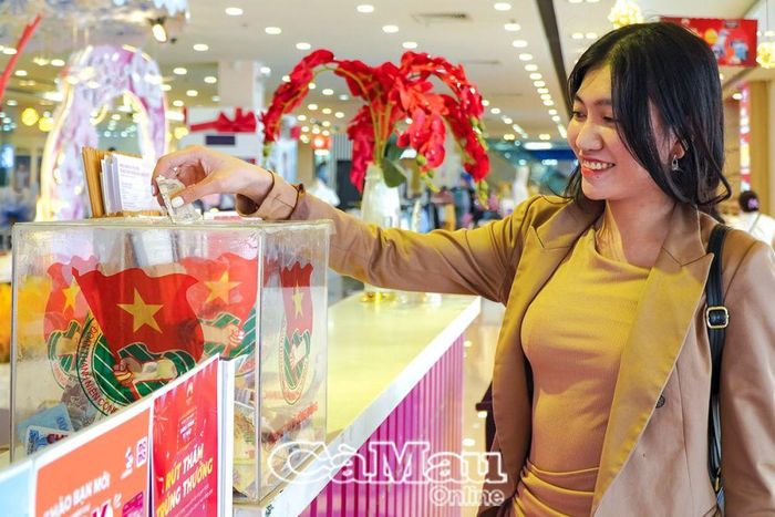 Một vị khách góp tấm lòng vào thùng từ thiện “Chung tay vì cộng đồng”, đặt tại Sense City Cà Mau.