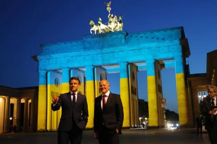 Tổng thống Pháp Emmanuel Macron và Thủ tướng Đức Olaf Scholz đứng trước Cổng Brandenburg, được chiếu sáng bằng màu cờ Ukraine, ở Berlin, ngày 9/5/2022. Tự chủ chiến lược của châu Âu là một khái niệm không chỉ bao gồm các vấn đề quốc phòng mà còn cả an ninh theo nghĩa rộng hơn. Ảnh: Getty Images