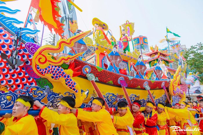 Các thanh niên trai tráng trong làng đưa thuyền rồng đi dọc bờ biển. Ảnh: Đình Minh
