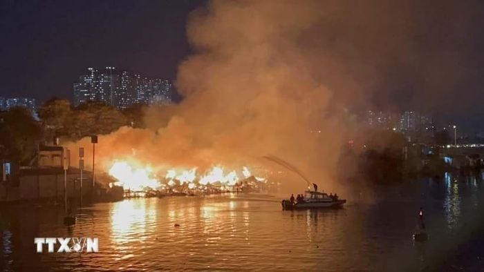 Cảnh sát Phòng cháy chữa cháy sử dụng canô chuyên dụng phun nước vào đám cháy. Ảnh: TTXVN