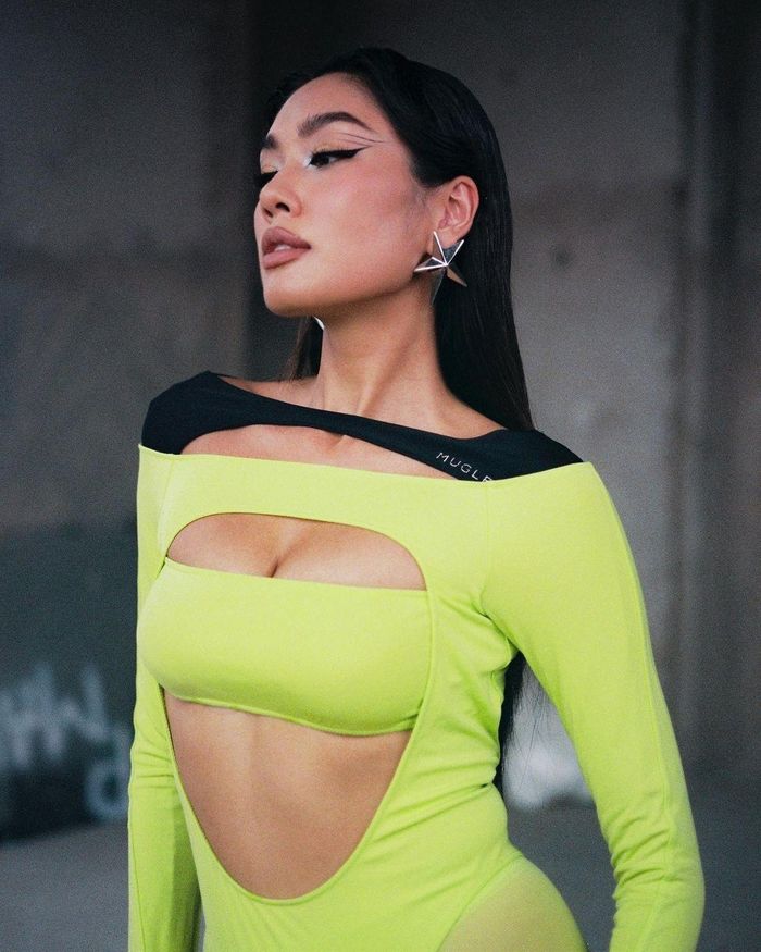  Một thiết kế catsuit ấn tượng khác được Thảo Nhi Lê lăng xê có màu xanh neon nổi bật. Bộ đồ này cũng là sản phẩm đến từ thương hiệu Mugler. Điểm nhấn của set trang phục này là chi tiết cut-out phía trước ngực, giúp người mặc phô diễn vòng một đầy đặn. Thảo Nhi tiếp tục trang điểm, chọn phụ kiện lấy cảm hứng từ loài mèo. Cụ thể, cô vẽ mắt mèo, đeo găng tay đen, chọn giày cao gót mũi nhọn quyến rũ, ghi điểm với hình tượng cá tính, bí ẩn. Ảnh: @thaonhile. 