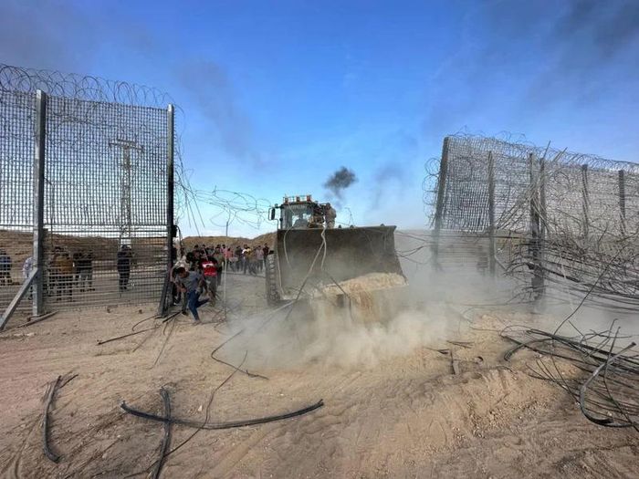Người Palestine tràn vào phía Israel qua hàng rào ranh giới Israel-Gaza, sau khi các tay súng Hamas xâm nhập vào các khu vực phía nam Israel, ngày 7/10/2023. (Ảnh: Reuters)