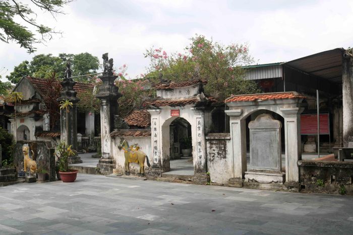 Tam quan của đền có 3 lối đi. Cửa chính có 2 trụ biểu gắn kết với 2 bức tường đắp hình ngựa cùng 2 cửa bên thiết kế theo kiểu chồng diêm lợp ngói. Ngay sát cửa bên phải có dựng bia đá cổ. Ảnh: Huy Thư