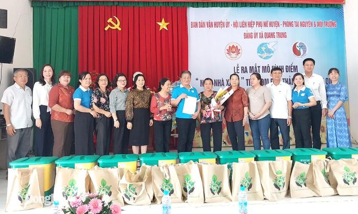 Lãnh đạo huyện và các nhà tài trợ tặng thùng rác hai ngăn cho các hộ gia đình tại buổi lễ. Ảnh: Nhật Quang