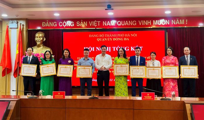 Chủ tịch HĐND quận Đống Đa Nguyễn Anh Cường khen thưởng các tập thể, cá nhân điển hình thực hiện Nghị quyết số 33-NQ/TƯ. Ảnh: Nguyệt Ánh