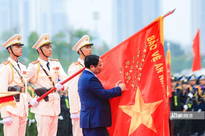 Thủ tướng Phạm Minh Chính gắn Danh hiệu Anh hùng Lực lượng vũ trang nhân dân lên cờ truyền thống của lực lượng Cảnh sát cơ động.