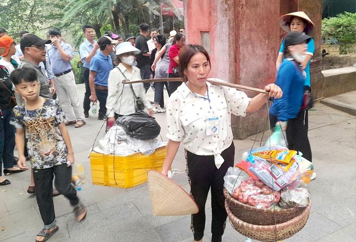 Những người gánh lễ thuê phải đeo thẻ do Ban quản lý Khu di tích lịch sử Đền Hùng cấp.