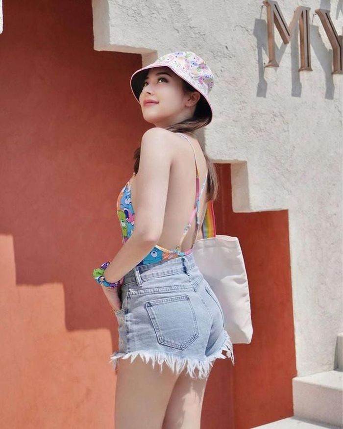 Diện monokini họa tiết gấu, nhiều sắc màu, Evelyn Sriabhandha trông trẻ trung, thu hút hơn. Cô phối cùng phụ kiện sắc màu đồng điệu gồm vòng tay, mũ và túi xách.