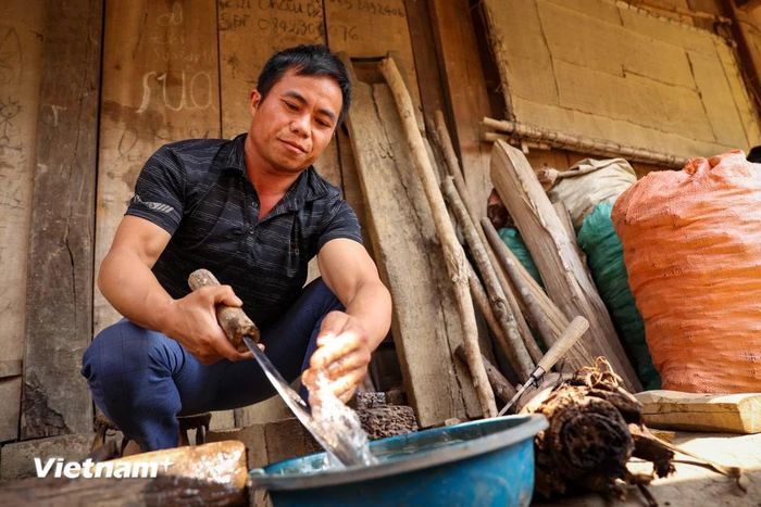  Anh Cứ A Dụ dùng đá suối và nước để mài dao cho sắc. (Ảnh: Hoài Nam/Vietnam+) 