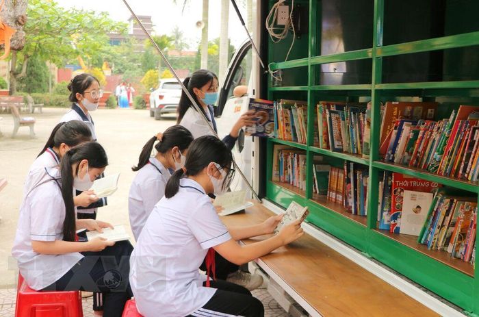 Học sinh quận Dương Kinh (Hải Phòng) hào hứng đọc sách từ xe lưu động(Ảnh: Minh Thu/TTXVN)