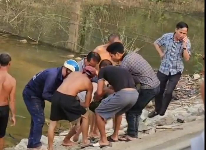 Thi thể 2 em học sinh được trục vớt lên bờ bàn giao cho gia đình lo thủ tục mai táng.
