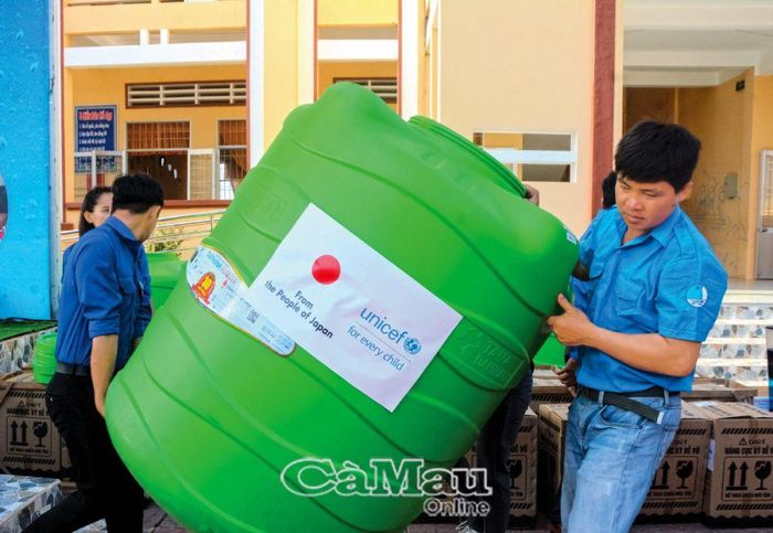 Lực lượng đoàn viên, thanh niên xã Khánh An di chuyển bồn chứa nước để hỗ trợ người dân đang khó khăn về nguồn nước.