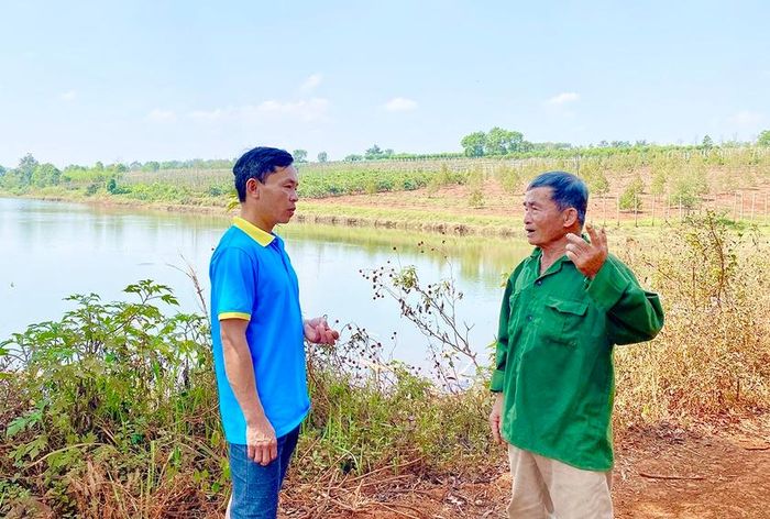 Ông Trần Đình Bông (bìa phải) bên “hồ ba Bông”-nguồn nước tưới cho hàng ngàn héc ta cà phê, sầu riêng ở khu vực này. Ảnh: H.D