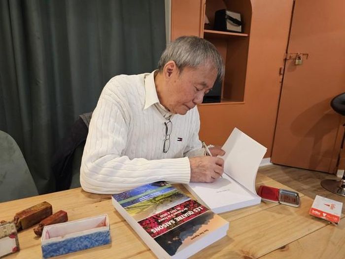 Giáo sư Nguyễn Quý Đạo ký tặng sách cho độc giả trong buổi ra mắt sách. Ảnh Ngọc Hiệp - PV TTXVN tại Pháp