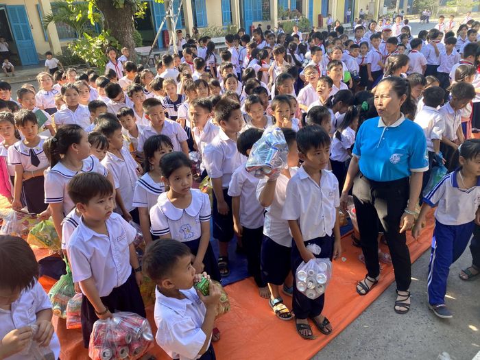 Các học sinh mang lon, giấy vụn để đổi lấy quà.