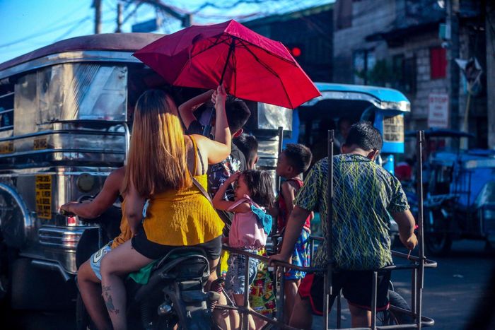  Người dân cố gắng chống chọi với nắng nóng khi di chuyển ở thành phố Navotas vào ngày 22/4. Ảnh: ABS-CBN News. 