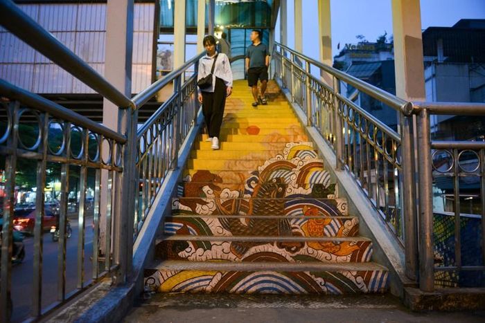 Phía chân cầu thang đi bộ, từ cả 2 hướng được vẽ các bức “Cá chép vượt vũ môn” từ kho tàng tranh dân gian Hàng Trống…