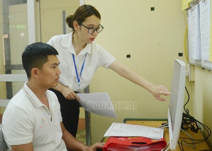  Cán bộ một cửa thị trấn Bát Xát hướng dẫn người dân khai báo trên Cổng dịch vụ công quốc gia. 