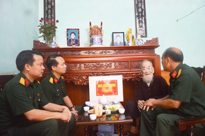 Chính ủy Bộ CHQS tỉnh Hoàng Nam Chung cùng các đồng chí trong đoàn lắng nghe tâm sự của cựu chiến sĩ Điện Biên. Ảnh: baovinhphuc.com.vn