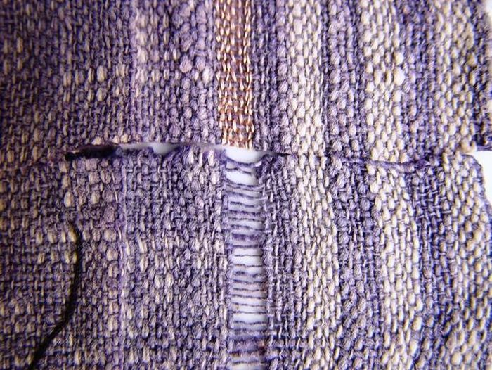 Miếng vải cạp váy cổ của người Mường dệt sợi bông (cotton) để trắng và nhuộm chàm lẫn với băng sợi tơ tằm vàng óng được cắt đôi dùng thí nghiệm ngâm trong một nửa trong dung dịch loãng axit sulfuric, và kết quả tương tự miếng vải Đông Sơn khai quật ở Động Xá