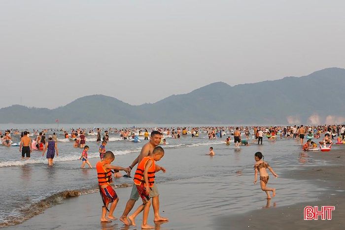 Sau khi ngâm mình trong dòng nước mát, nhiều gia đình lên bờ thư giãn với các trò chơi trên biển.