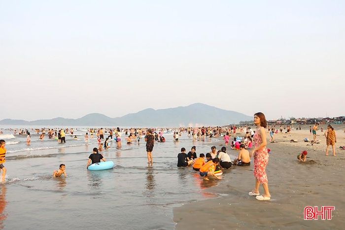 Trên bãi biển, dòng người đông đúc, nhộn nhịp.