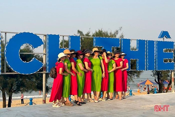 Theo thống kê sơ bộ, lượng công suất đặt phòng tại KDL Thiên Cầm trong ngày đầu kỳ nghỉ 30/4 và 1/5 đạt khoảng 80%, trong đó một số khách sạn đạt 90 - 100%. Trong ảnh: Đoàn du khách ngoại tỉnh check in tại biển hiệu KDL Thiên Cầm.