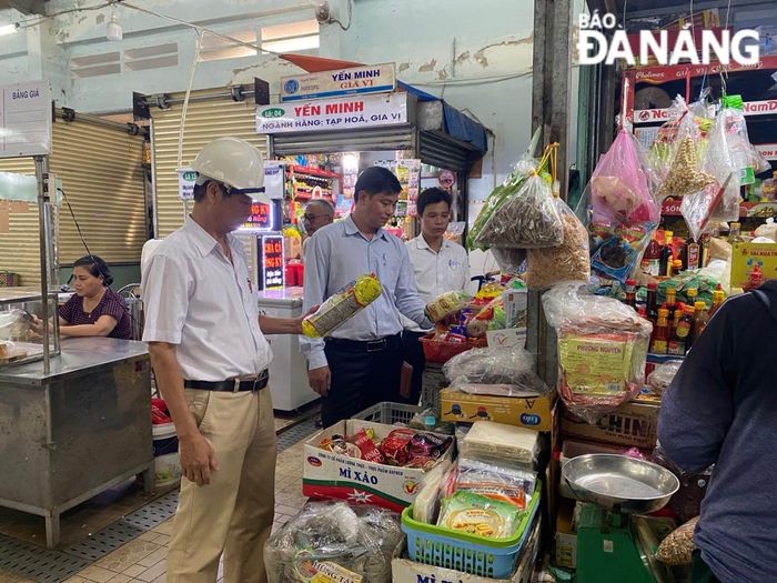 Ban Quản lý An toàn thực phẩm kiểm tra các mặt hàng tại chợ. ẢNH: ĐVCC