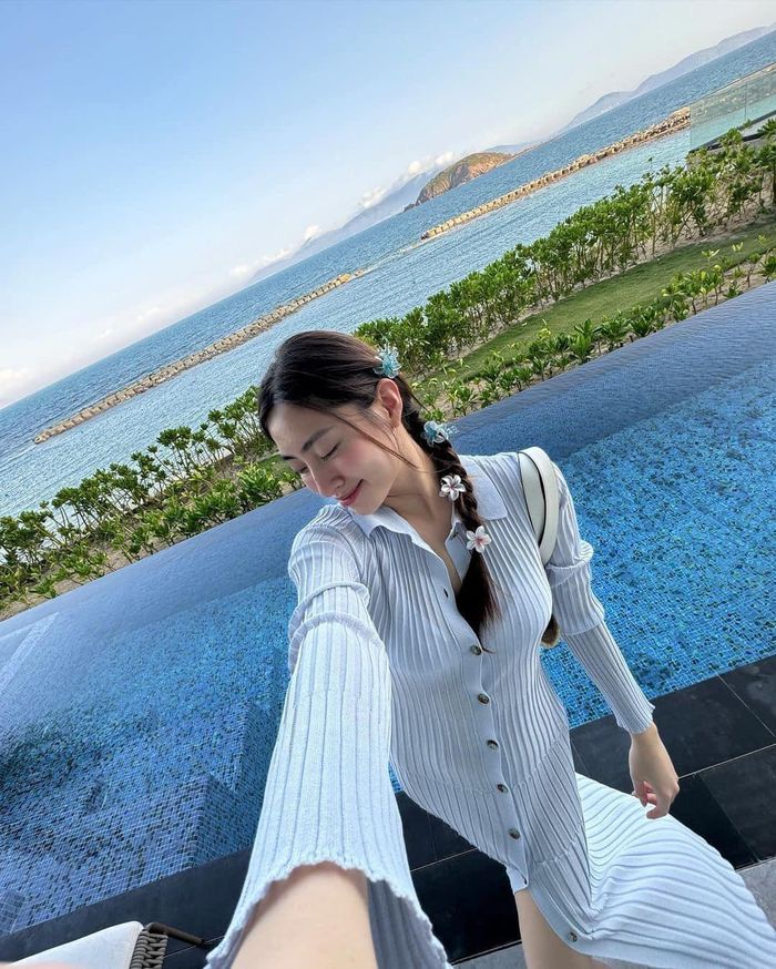 Lương Thùy Linh "trốn nóng" trong một khu resort bên bãi biển. Hoa hậu chọn set bikini hai mảnh nhưng được che chắn bởi áo khoác dáng dài kín đáo. Cô kết hợp thêm túi xách và một số phụ kiện đi kèm.