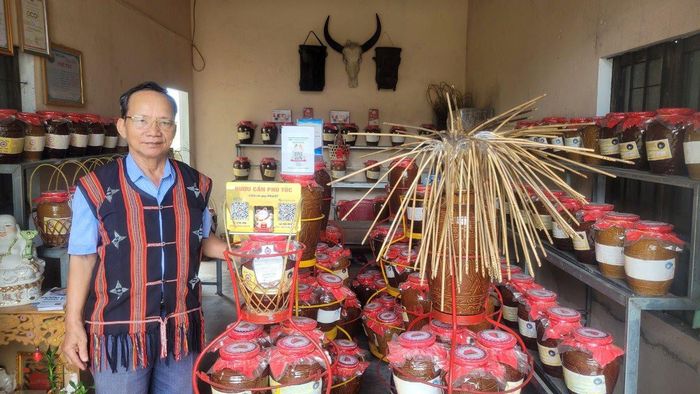 Ông Đinh Văn Nghĩa, Trưởng làng Hòa Phú với sản phẩm rượu cần truyền thống. Ảnh: Thanh Tùng.