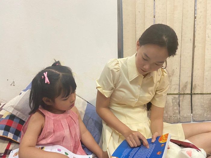  Nguyễn Minh Châu (21 tuổi, diễn viên múa) đang cùng cháu đọc sách. Ảnh: Đức Huy. 