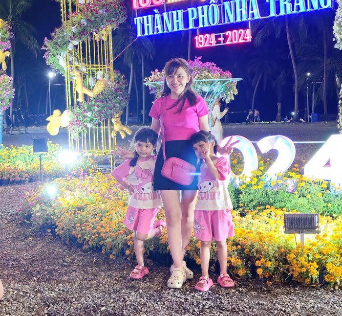 Gia đình tạo dáng chụp hình bên tháp hoa trên đường Trần Phú.