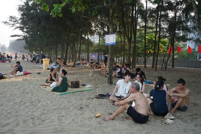 Người dân ngồi nghỉ ngơi trước lúc xuống biển tắm.