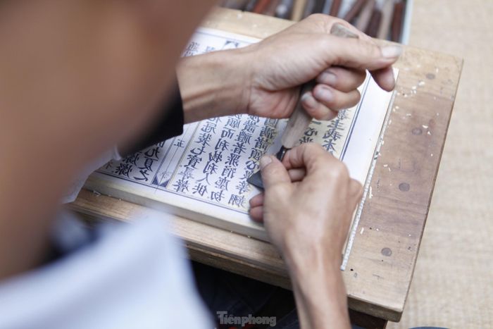 Anh Thạo chia sẻ, đôi tay phải cứng để khoét gỗ đủ sâu, lại vừa đủ mềm để khắc được những nét phẩy, nét mác, nét móc. Riêng nét móc lại có cả chục kiểu, phải làm sao lột tả đúng được những đường nét khi đuôi chữ hất lên, khi mềm mại bay bổng, khi rắn rỏi. Ảnh: Nguyễn Thắng