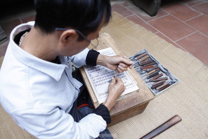 Anh Thạo cho biết, khắc mộc bản kinh Phật lên tấm ván gỗ thị là công việc đòi hỏi tỉ mỉ, nhiều công phu và tâm huyết. Khắc mộc bản đòi hỏi sự tỉ mẩn, chính xác gần như tuyệt đối từng nét chữ. Chữ khắc kích thước bé tí, có chữ chỉ 5 milimét. Ảnh: Nguyễn Thắng