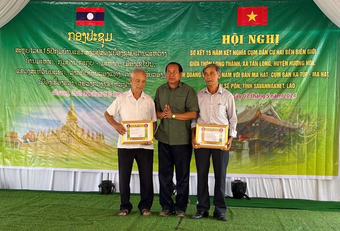 Ông Bun Lọm Sủ Fa Mi Xay, Phó Bí thư Huyện ủy Sê Pôn trao tặng giấy khen cho tập thể và cá nhân thôn Long Thành, xã Tân Long, Hướng Hóa. Ảnh: Phước Trung