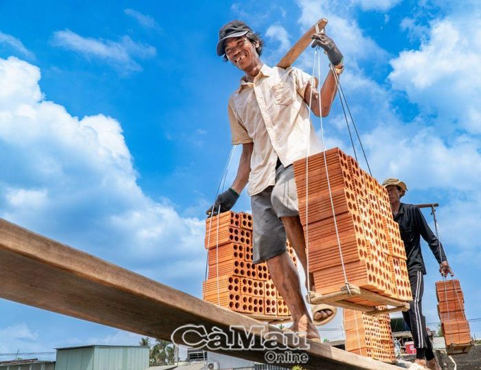 Ðôi chân khéo léo đi trên những tấm ván bắc từ ghe gạch đấu nối đến bờ sông.