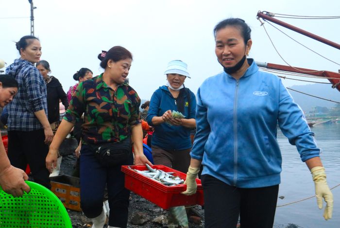 Các tiểu thương vui mừng vì thu mua được những giỏ hải sản tươi mang đi bán.