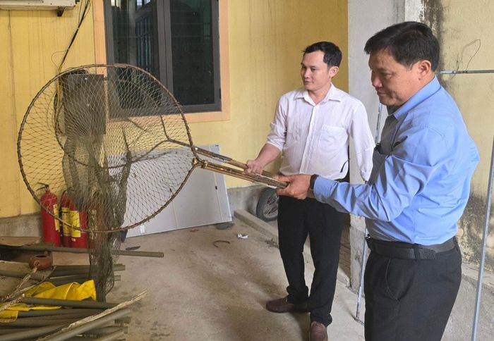  Ông Đàm Văn Chính (áo xanh), cho biết, xã Diễn Nguyên cũng đã lập tổ tuần tra, sắm vợt để bắt chó nhưng chỉ được thời gian ngắn phải giải tán, vợt bị vứt trong nhà kho. Ảnh: Tiến Hùng 