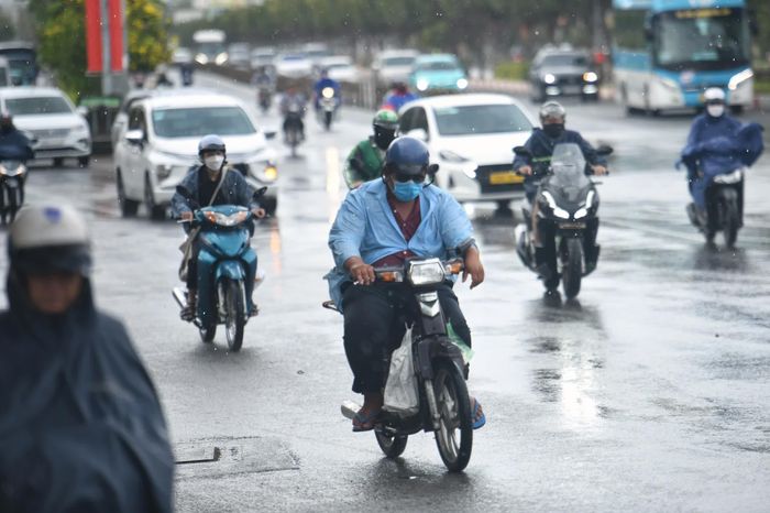 Bên cạnh đó cũng có nhiều người đi đường không kịp mặc áo mưa, phải phóng xe dưới cơn mưa tầm tã trút xuống đường Điện Biên Phủ (quận Bình Thạnh) vào khoảng 14h30.