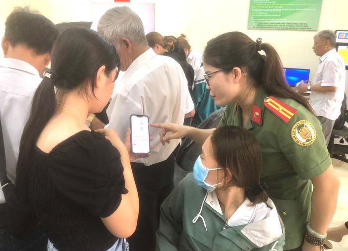 Thiếu tá Bùi Thị Phượng tận tình hướng dẫn người dân đến làm thủ tục cấp hộ chiếu.