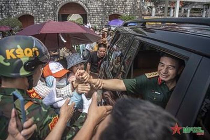 Đại tướng Phan Văn Giang, Ủy viên Bộ Chính trị, Phó bí thư Quân ủy Trung ương, Bộ trưởng Bộ Quốc phòng đón nhận tình cảm nồng nhiệt của đồng bào địa phương. Ảnh: MẠNH QUÂN
